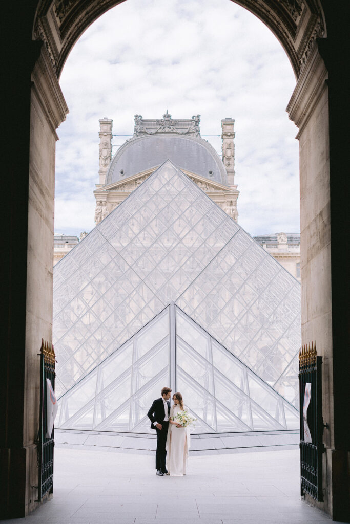 Paris wedding photograph of a couple in front of Louvre's pyramid