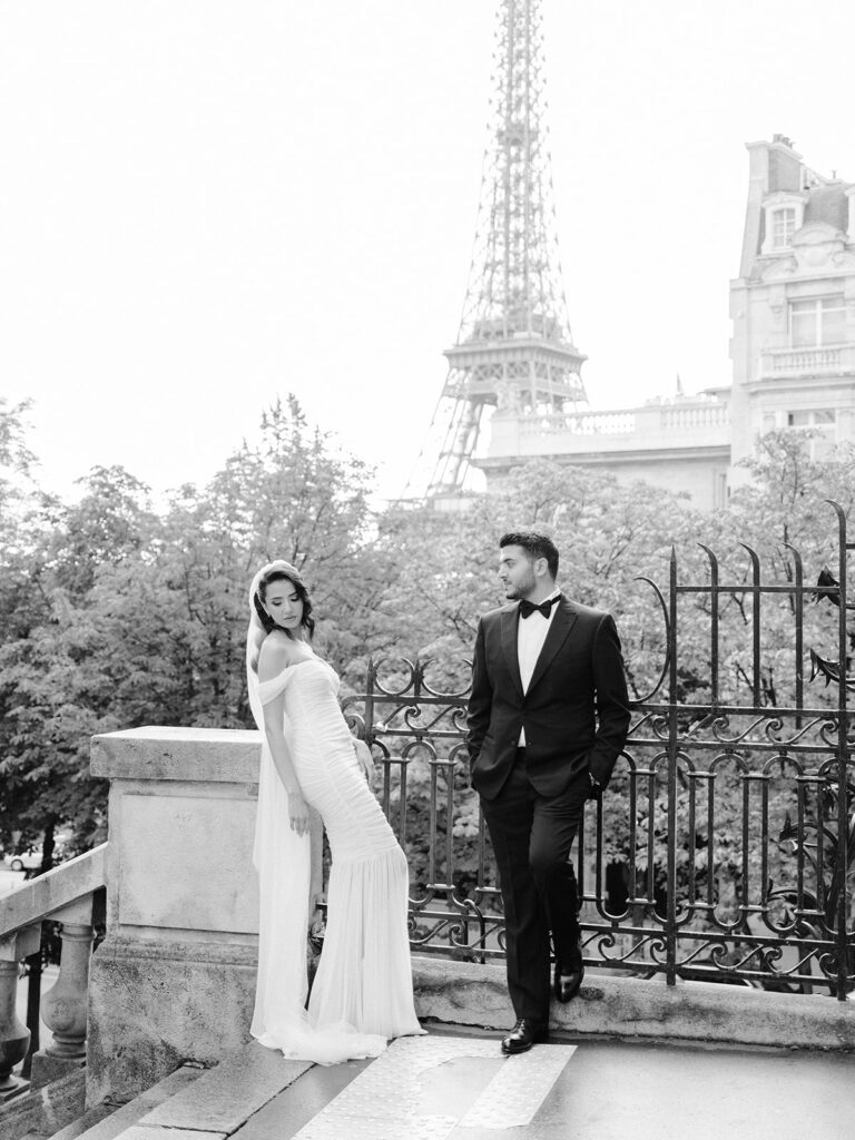 Black and white photography of a couple posing in a street with Eiffel Tower view