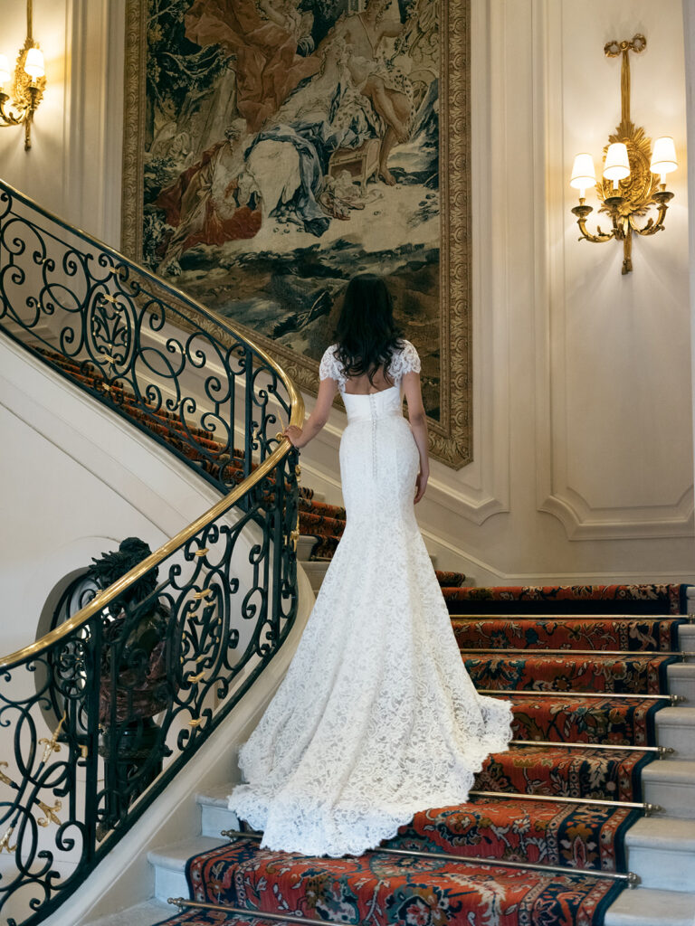 Bride photographed from behind on a staircase at the Ritz Paris