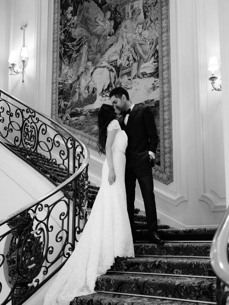 Black and white wedding photograph of a couple on a staircase at the Ritz Paris