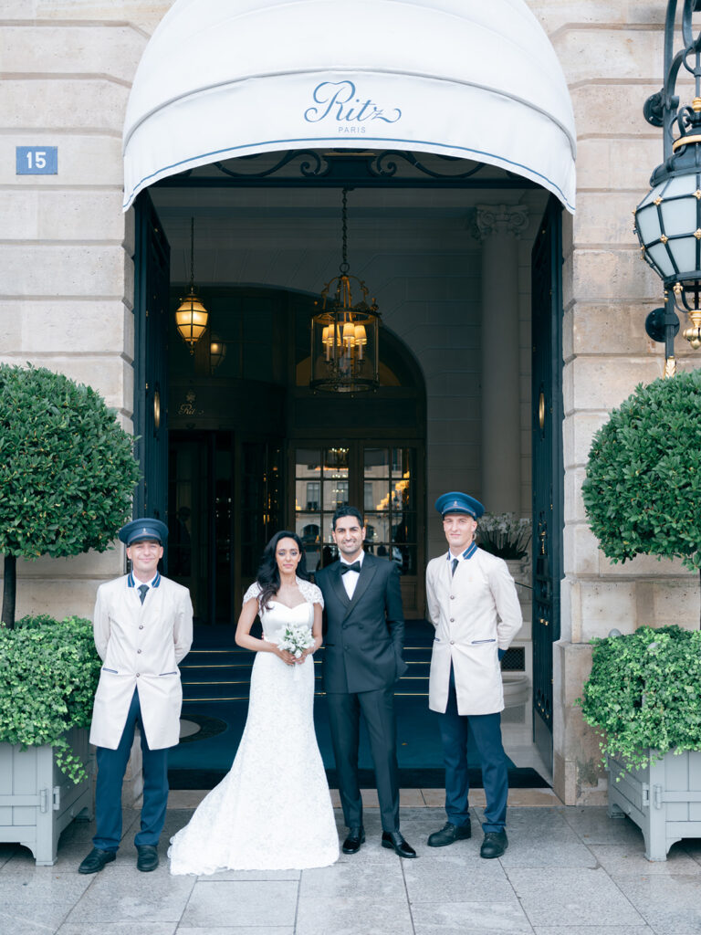 Bride and groom photographed in front of Ritz Paris with the staff