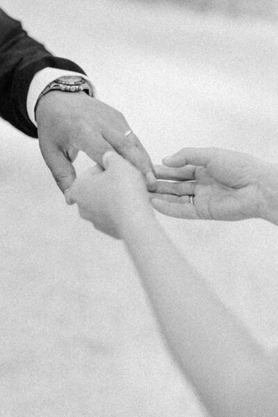 Bride putting the ring at her groom's finger
