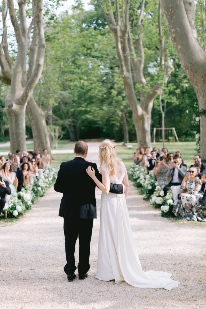 des mariés qui se tiennent dans les bras devant leurs invités au chateau de fonscolombe