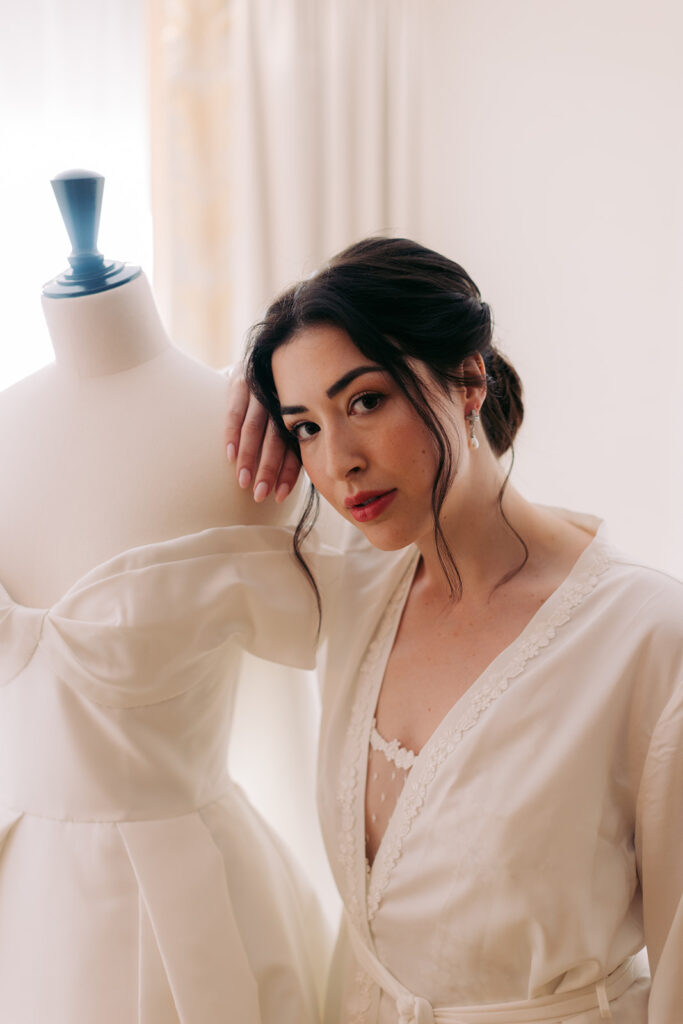 Wedding photography of a bride posing next to a display mannequin