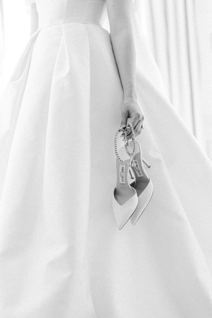 Black and white wedding photography of the bride's heels and dress at Shangri La Paris